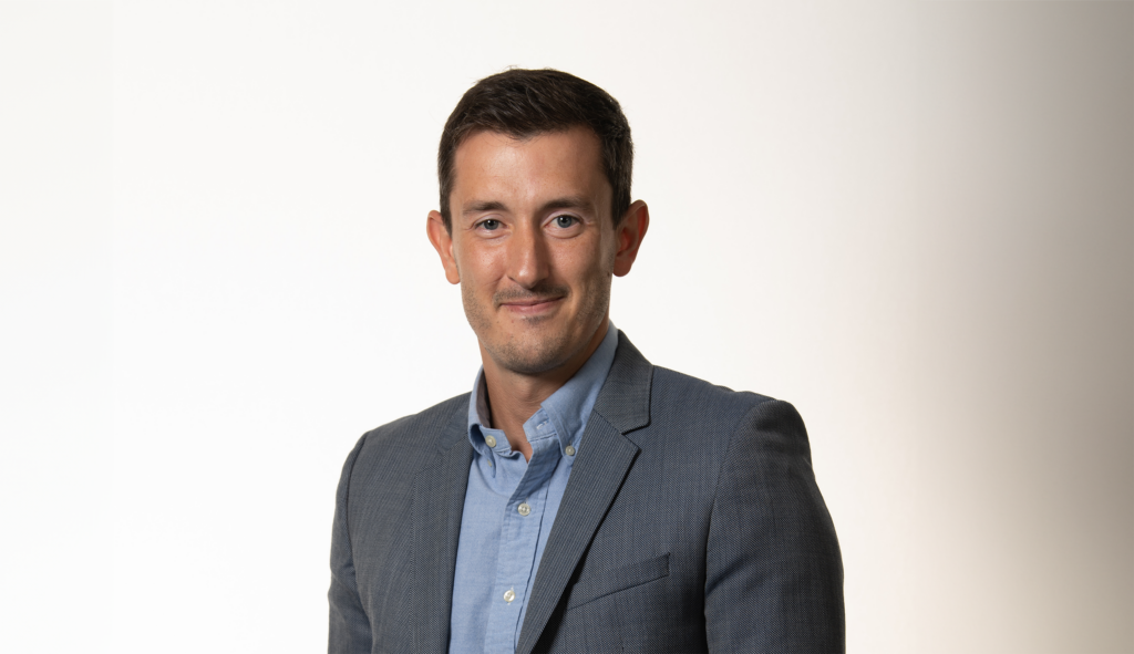 Man in blazer smiling in studio shot