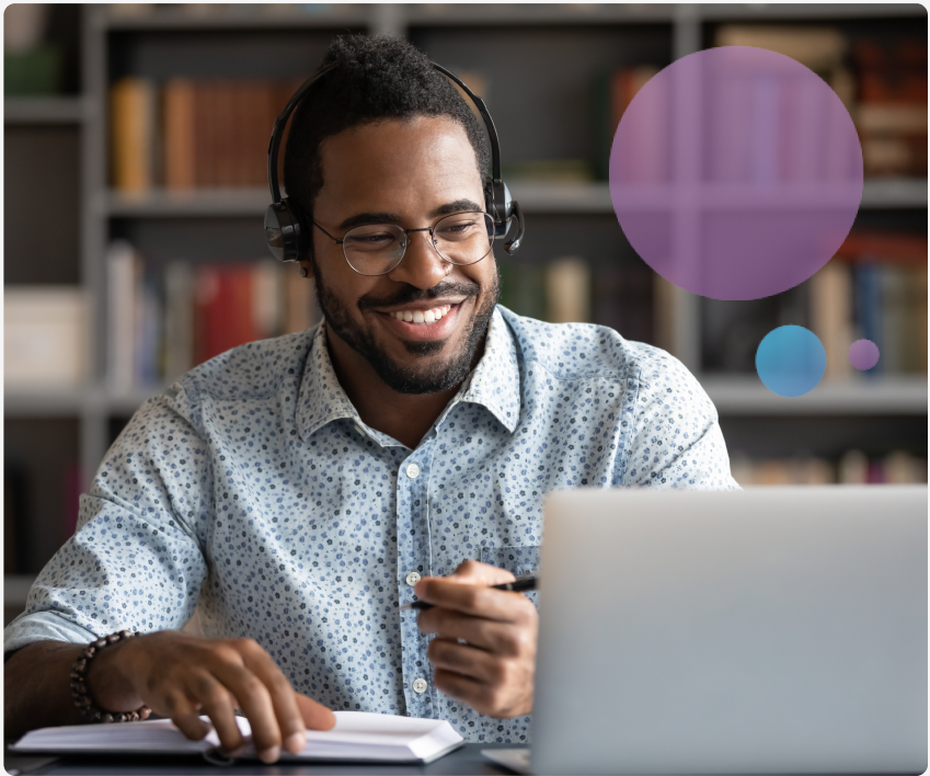 Man smiling in library working on laptop