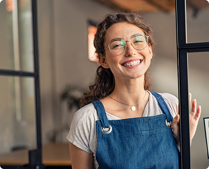 Smiling woman in apron in cafe