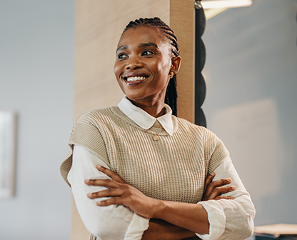 Woman in cream blazer smiling indoors