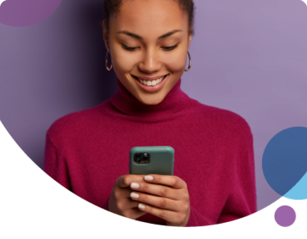 Woman smiling while using phone in red sweater