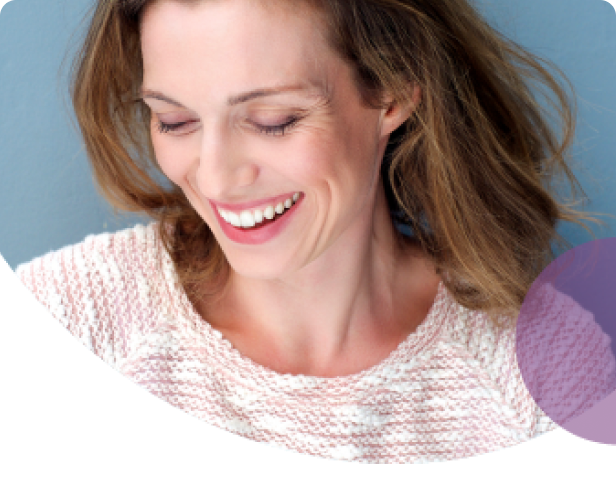 Woman smiling and looking down on grey background