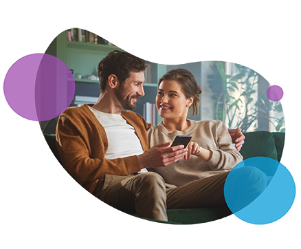 Couple smiling and talking on couch with abstract background