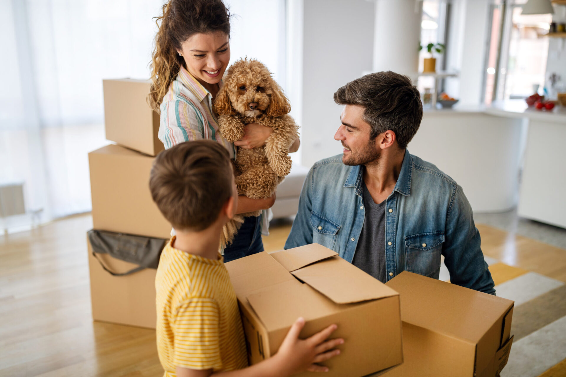 Family smiling and unpacking with child and dog