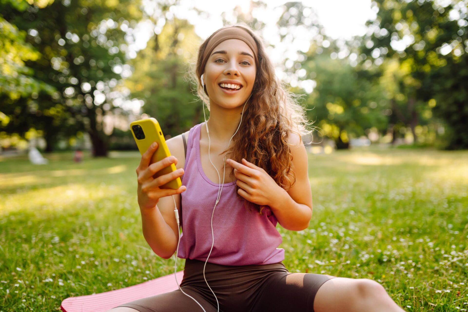 Woman smiling with a smartphone outdoors