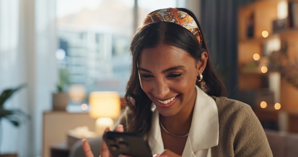 Woman smiling while using smartphone