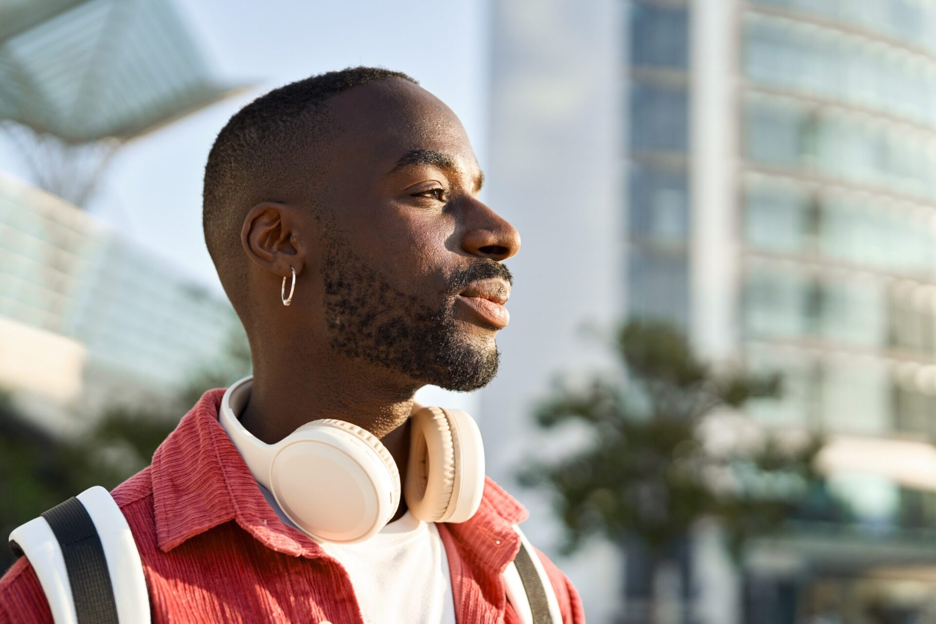 Man smiling outdoors wearing headphones