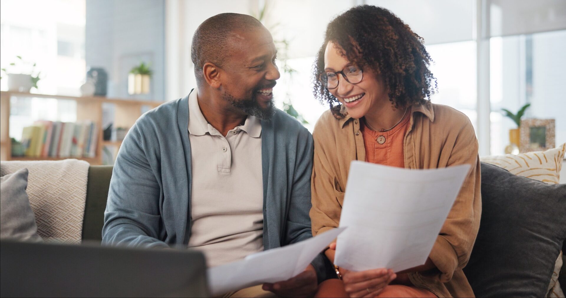 Man and woman smiling while reviewing paperwork