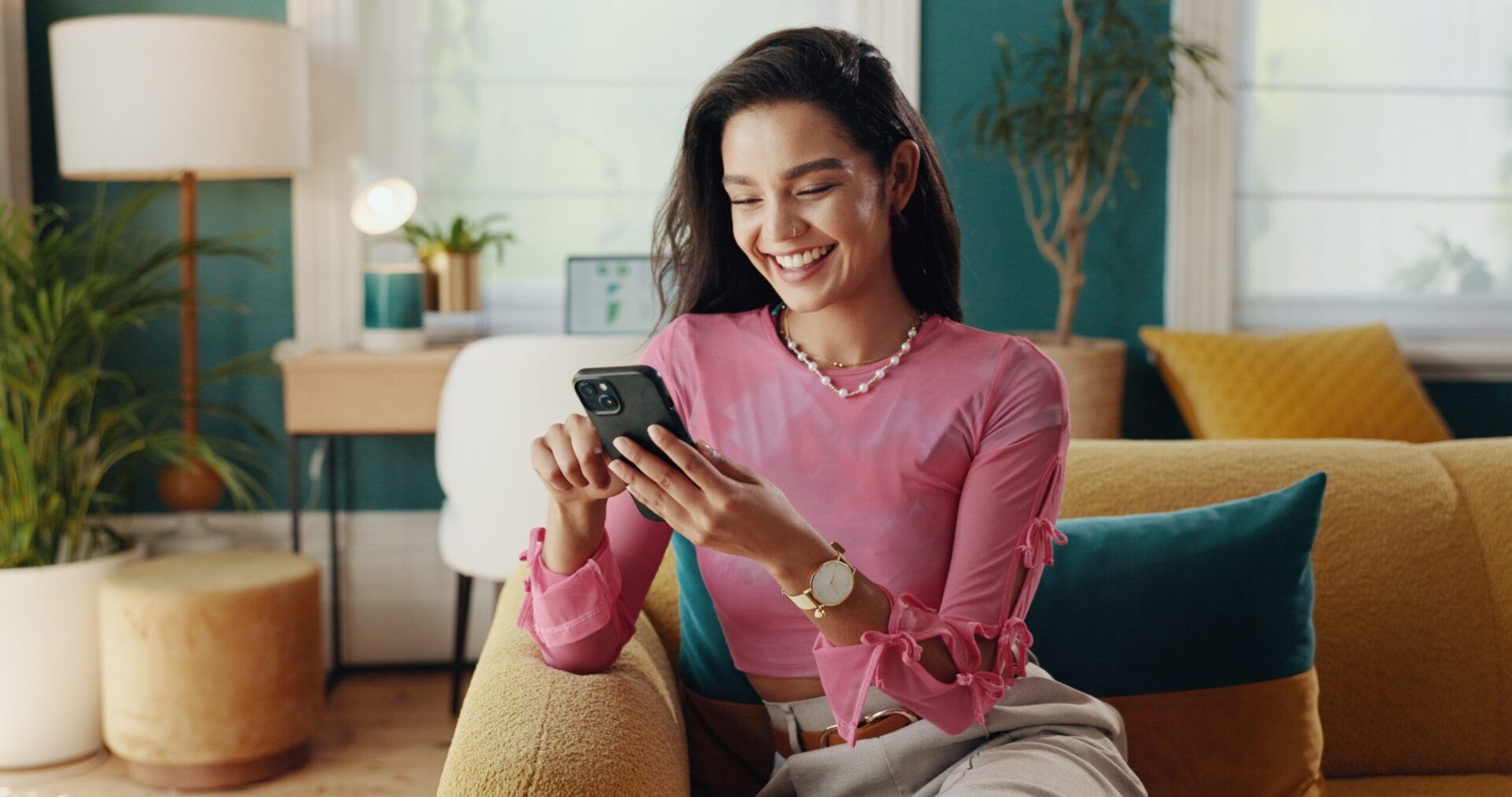 Woman sitting on couch using smartphone